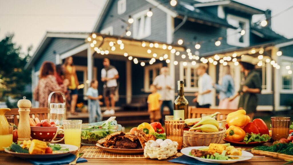 Table filled with summer foods in backyard with family
