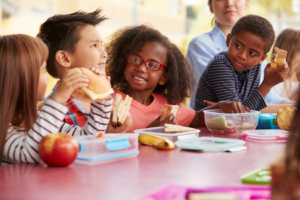 a group of kids eating lunch at school